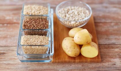 diet, cooking, culinary and carbohydrate food concept - close up of grain and beans in glass bowls with potatoes on table