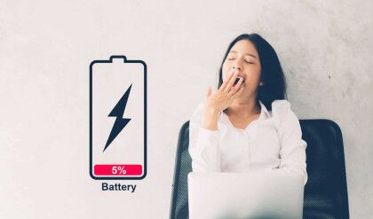 Young asian woman yawn at her work place with laptop computer on cement background, girl working with yawn and burnout with symbol battery low, stress and tired, copy space, business concepts.