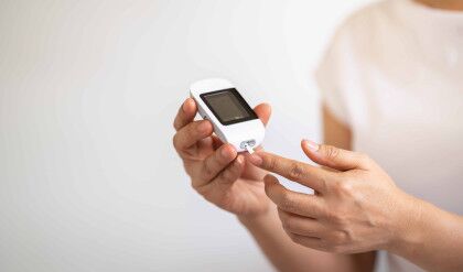 Close up of woman hands using Glucose meter on finger to check blood sugar level. Use as Medicine, diabetes, glycemia, health care and people concept.