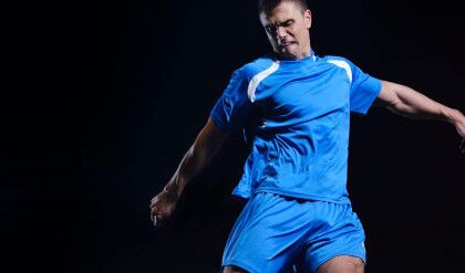 soccer player doing kick with ball on football stadium  field  isolated on black background