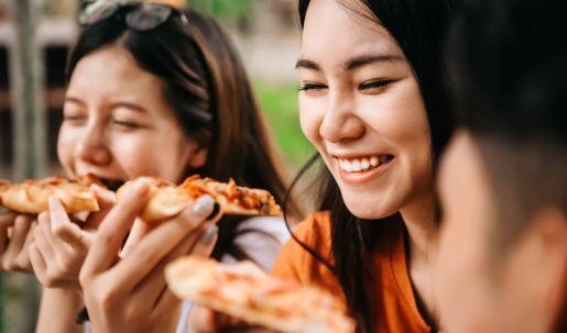 Asian,Students,Eating,Eating,The,Pizza,Together,In,Breaking,Time